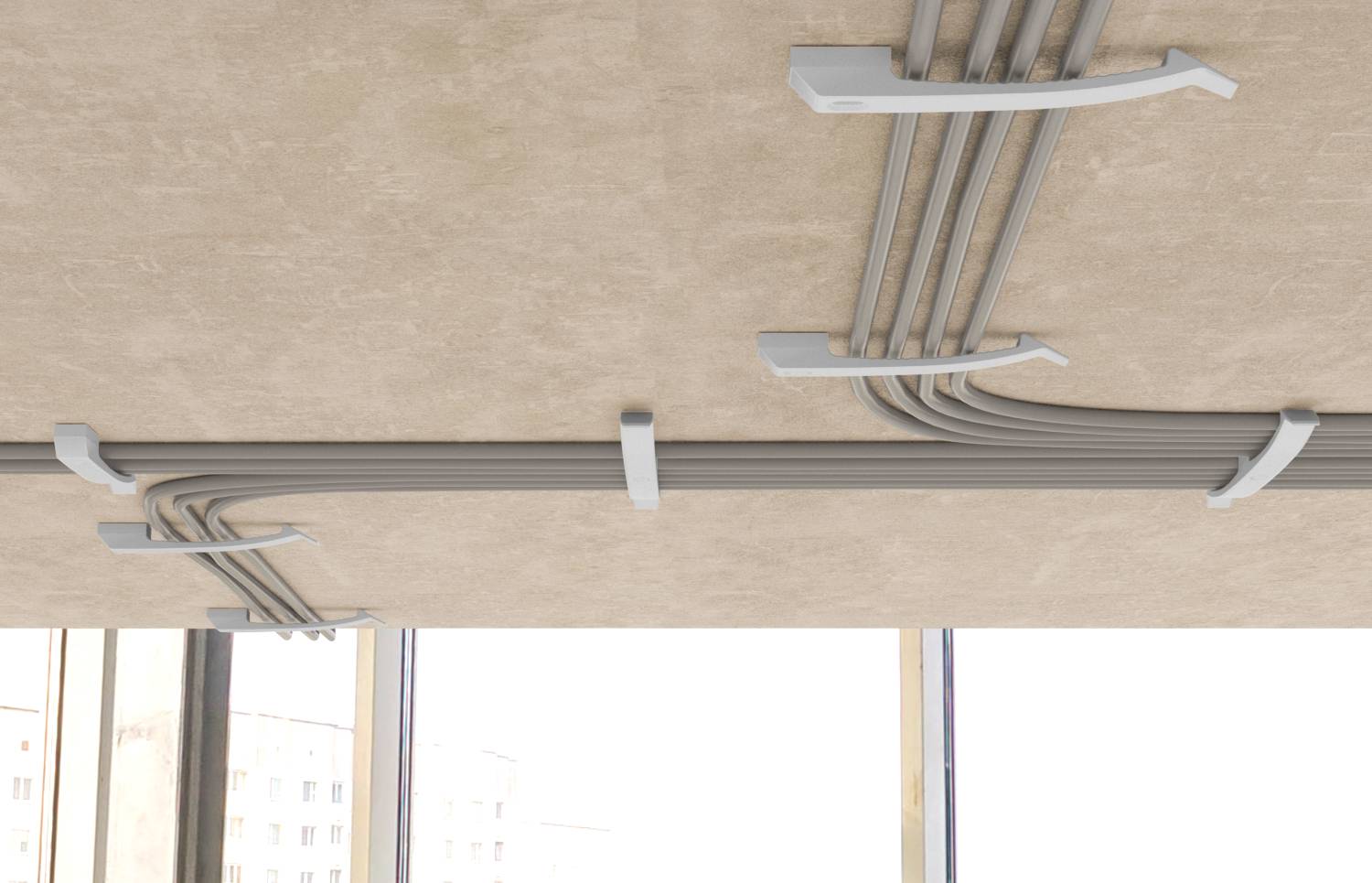 Conduits de gestion des câbles montés au plafond et clips maintenant des câbles gris groupés au-dessus de fenêtres lumineuses.