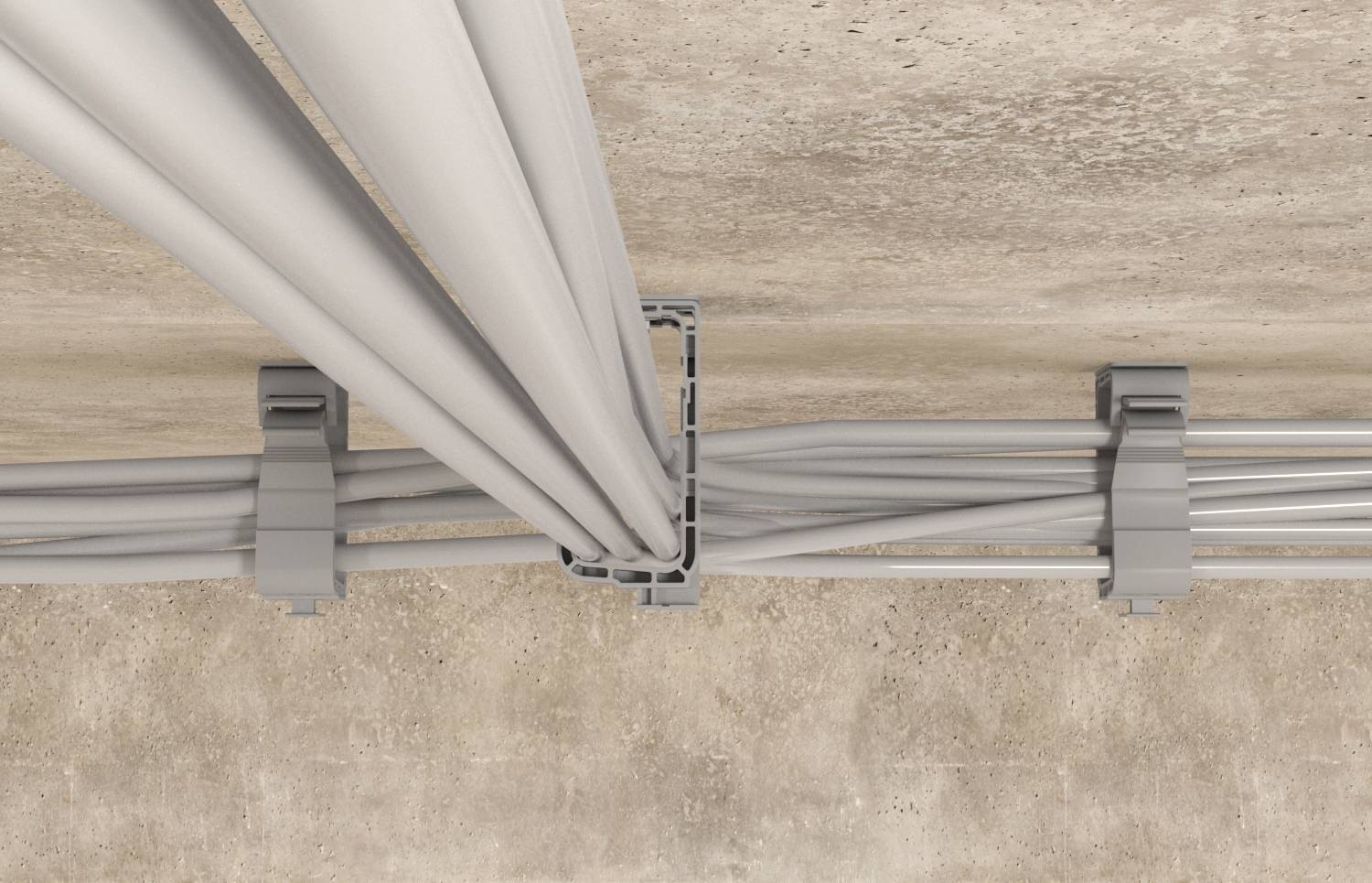 Câbles électriques gris acheminés à travers un chemin de câbles au sol, divisés et guidés par des supports métalliques dans un espace en béton.