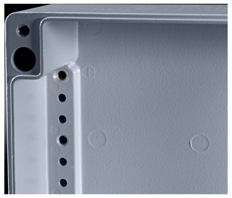 Un boîtier métallique rectangulaire gris avec plusieurs ouvertures rondes et un filetage de vis encastré en haut à gauche.