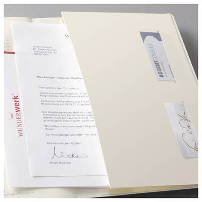 Ouvrir des dossiers de couleur crème ou des dossiers contenant des lettres commerciales et une couverture WUNDERwerk, affichant de la correspondance allemande imprimée et des étiquettes à onglets.