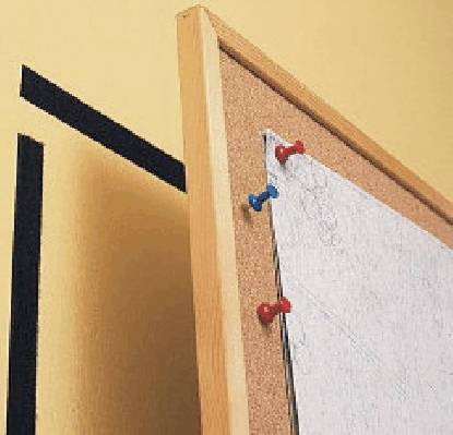 Une feuille de papier est fixée à un tableau d'affichage avec des punaises de couleur. Le mur est de couleur jaune.