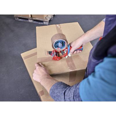 Une personne applique du ruban adhésif sur un carton à l'aide d'un dérouleur. À l'arrière-plan, un autre carton est posé sur une palette.