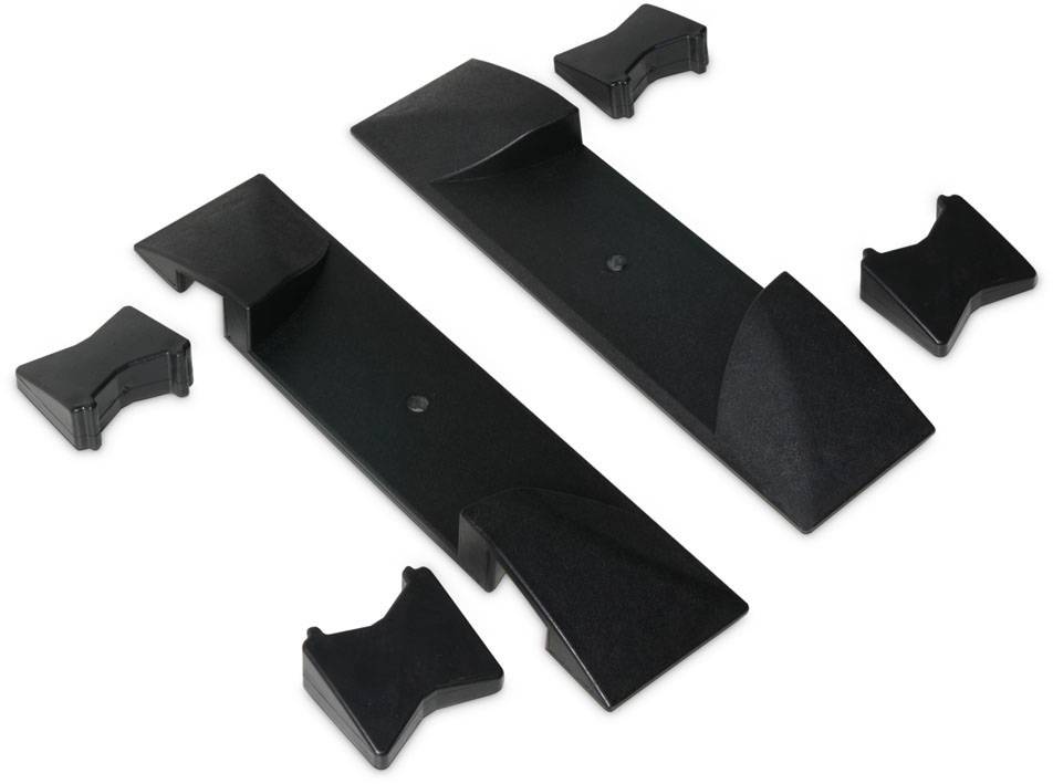 Des pièces en plastique noir de différentes formes, qui semblent s'emboîter, sur un fond blanc.