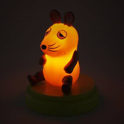 Une figure de souris lumineuse avec un corps orange et des oreilles sombres est assise sur une plateforme ronde devant un arrière-plan sombre.