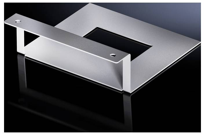 Une pièce métallique argentée, rectangulaire, avec un évidement carré au centre, repose sur une surface noire brillante.
