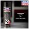 Bombe aérosol 'LIQUI MOLY' utilisée sous un véhicule pour appliquer une protection du soubassement. Texte sur la bombe : 'Mélange thixotropique, haute résistance à l'abrasion'.