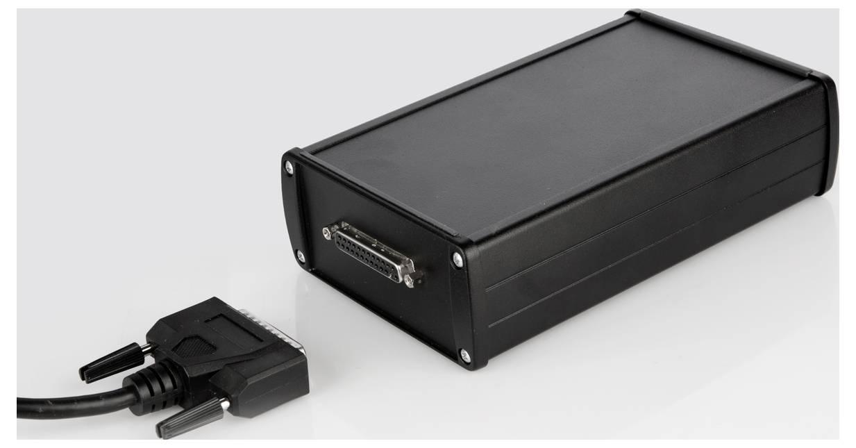 Un appareil noir rectangulaire avec une prise de connexion et une fiche correspondante avec un câble, positionné dans une pièce lumineuse.