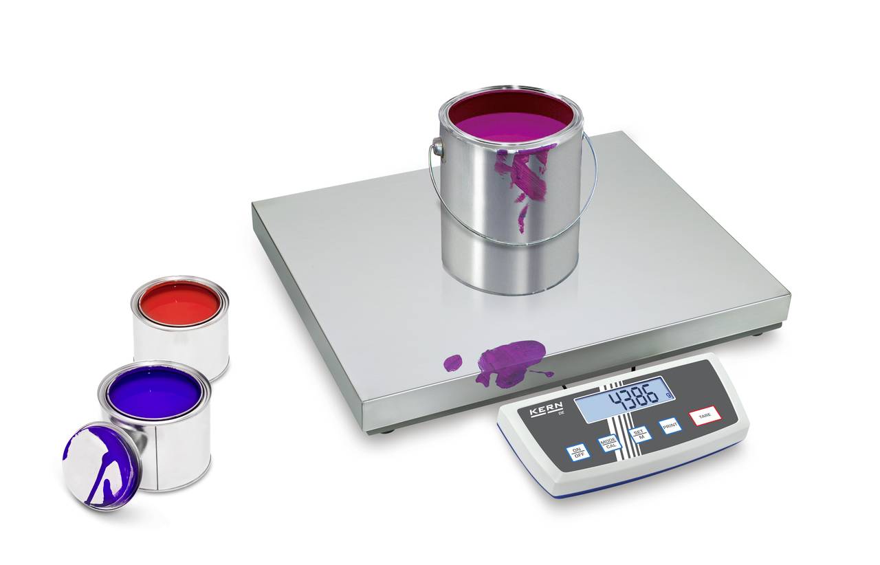 'Trois boîtes de peinture ouvertes en rouge, bleu et violet sur une balance numérique ; la balance indique 4386 grammes.'