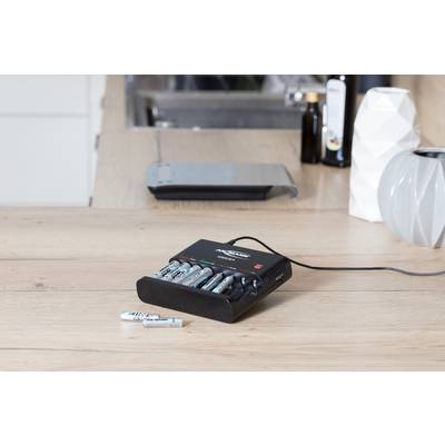 Chargeur de piles AA sur une table en bois, plusieurs piles étant chargées simultanément.