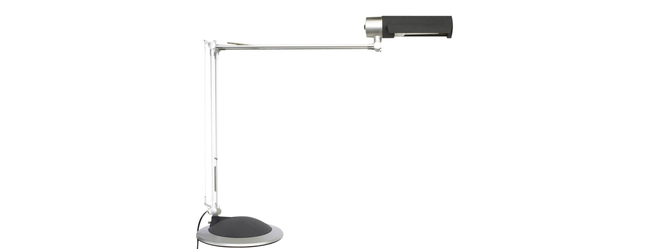 Lampe de bureau réglable avec tête rectangulaire noire et base ronde, présentée sur fond blanc uni.