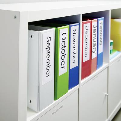 Classeurs sur une étagère, étiquetés avec les noms des mois de septembre à février. Couleurs : blanc, bleu, vert, rouge, orange.