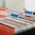 Classeur avec des intercalaires colorés dans une armoire de bureau, servant à l'organisation des documents.