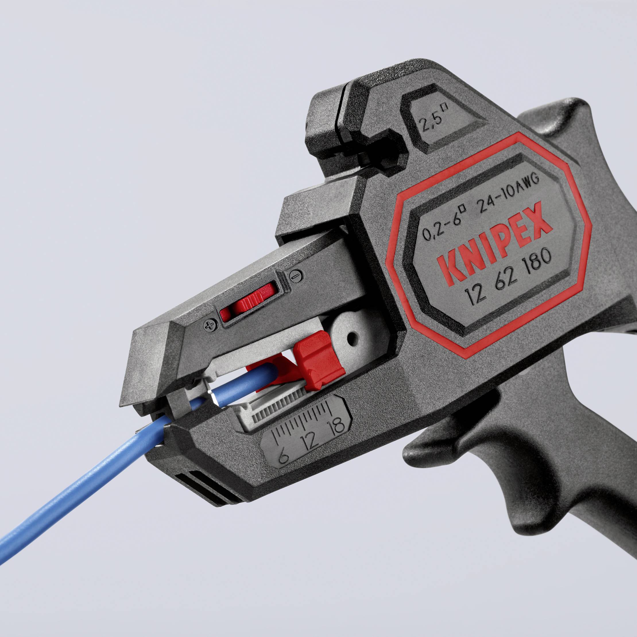 Pince à dénuder de Knipex en action. Elle serre un câble bleu pour retirer l'isolation avec précision.