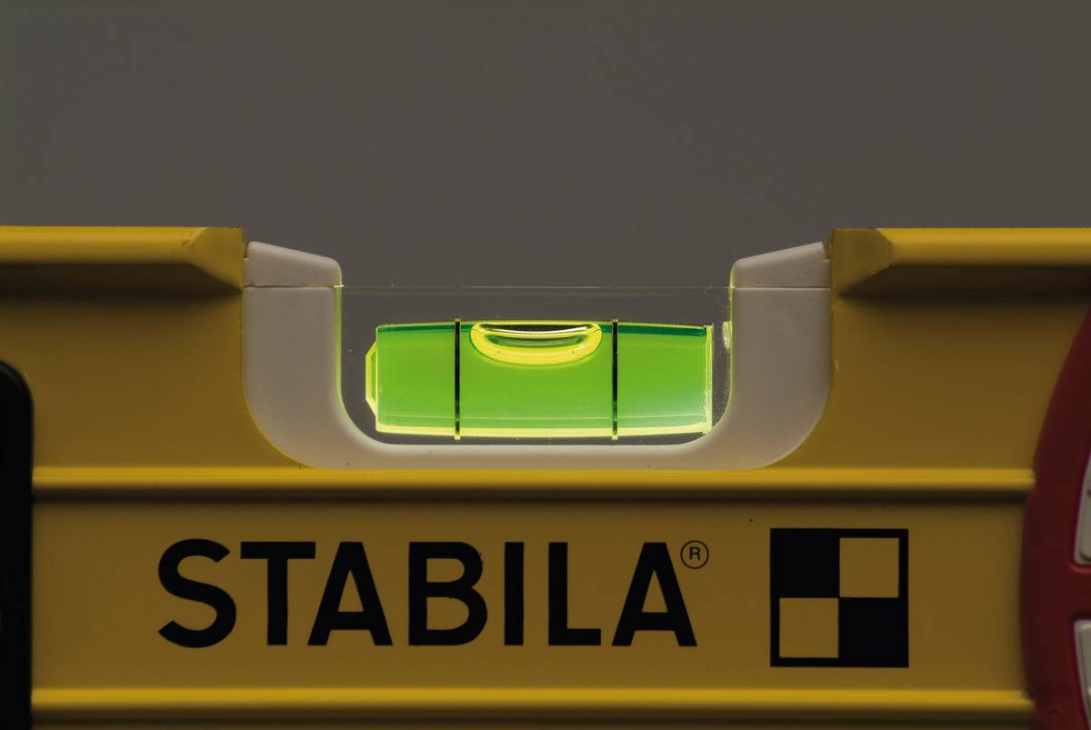 Un niveau à bulle jaune indique l'alignement correct ; la bulle d'air est centrée entre les repères.