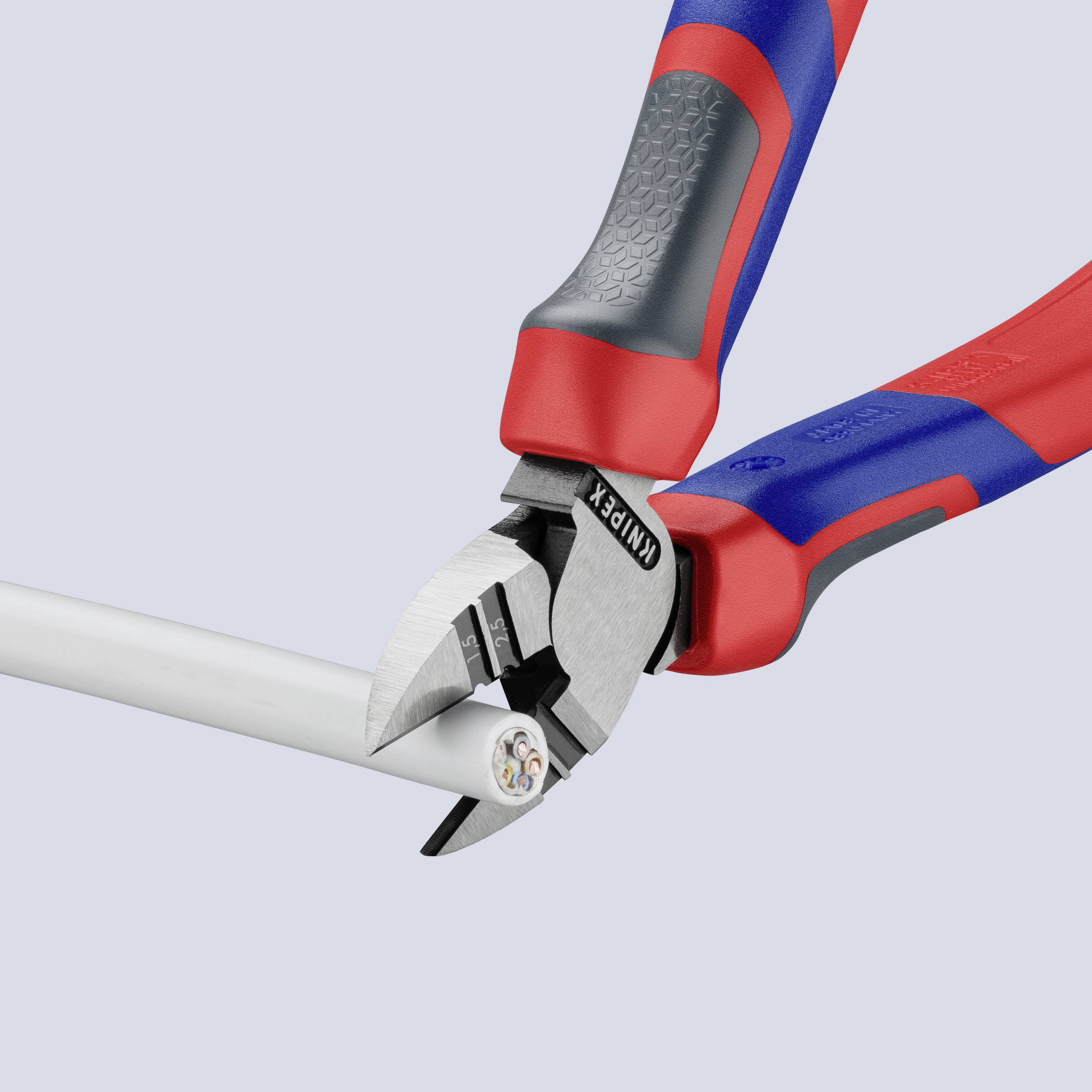 Une pince coupe-câble tranche un câble électrique blanc. Les poignées de la pince sont marquées en rouge et en bleu.