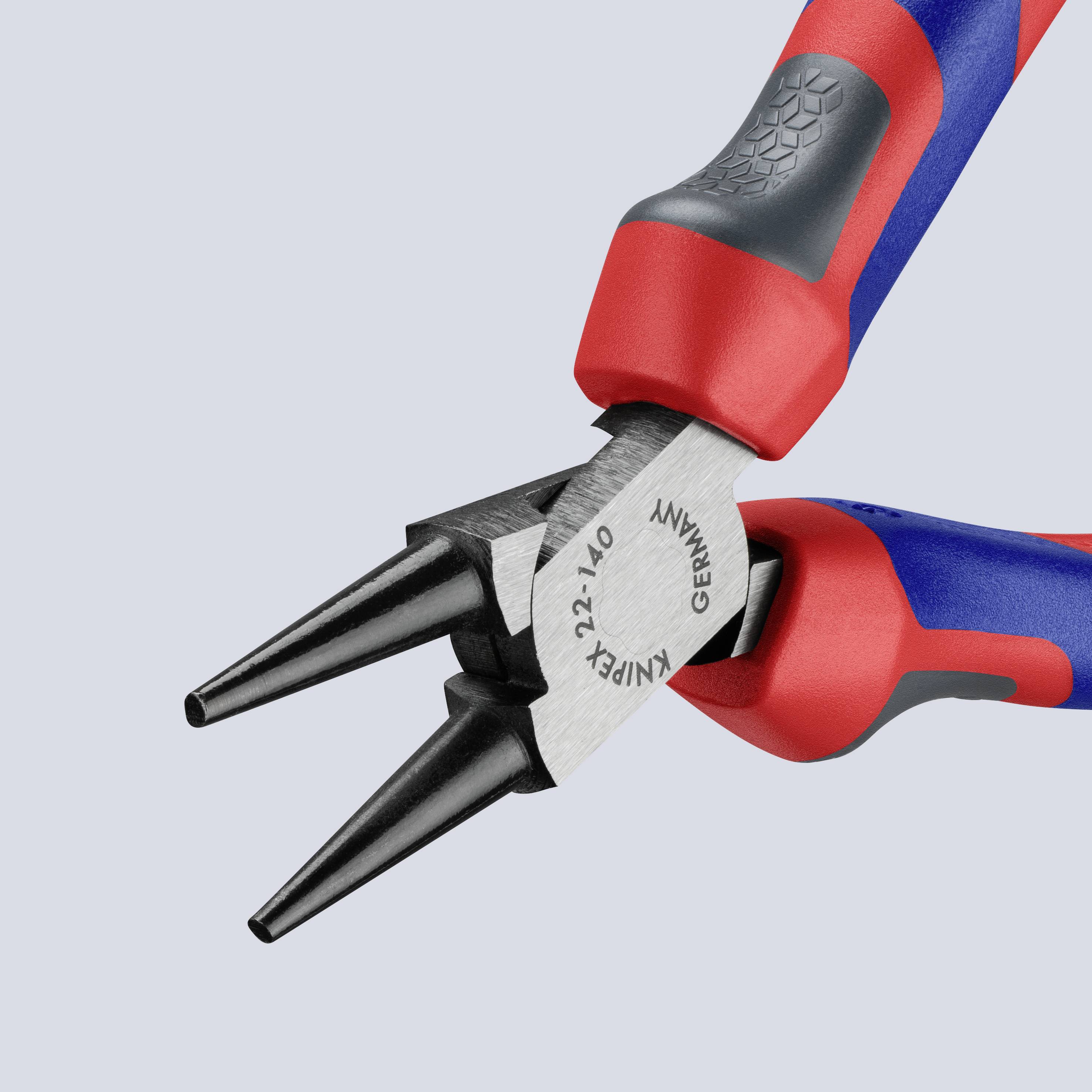 Deux pinces rouge et bleue, posées sur une surface grise, révèlent des pointes en acier. Des outils pour des travaux de précision.