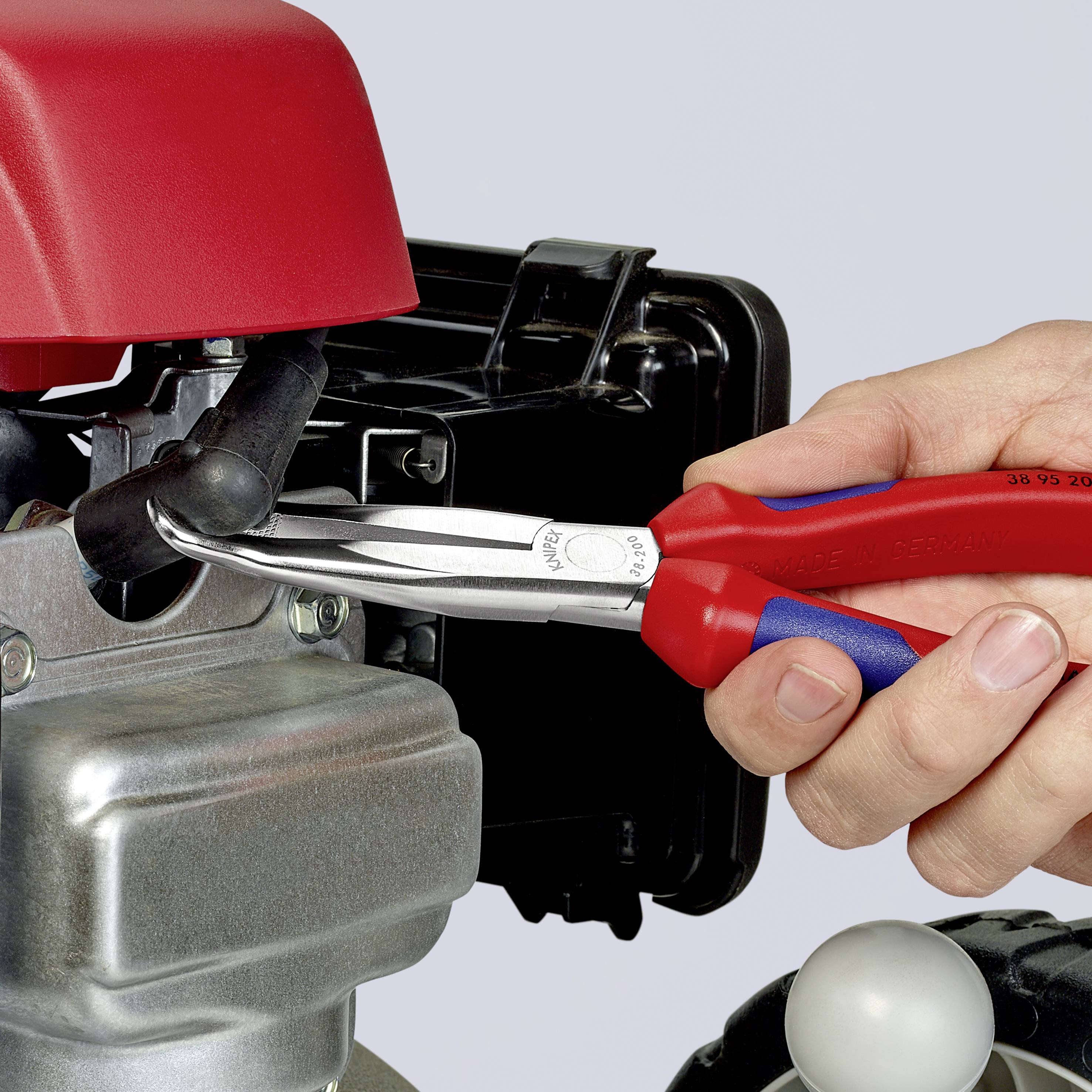 Une main tient une pince rouge et travaille sur un moteur, fixant un anneau de sécurité. Un entretien mécanique est en cours.