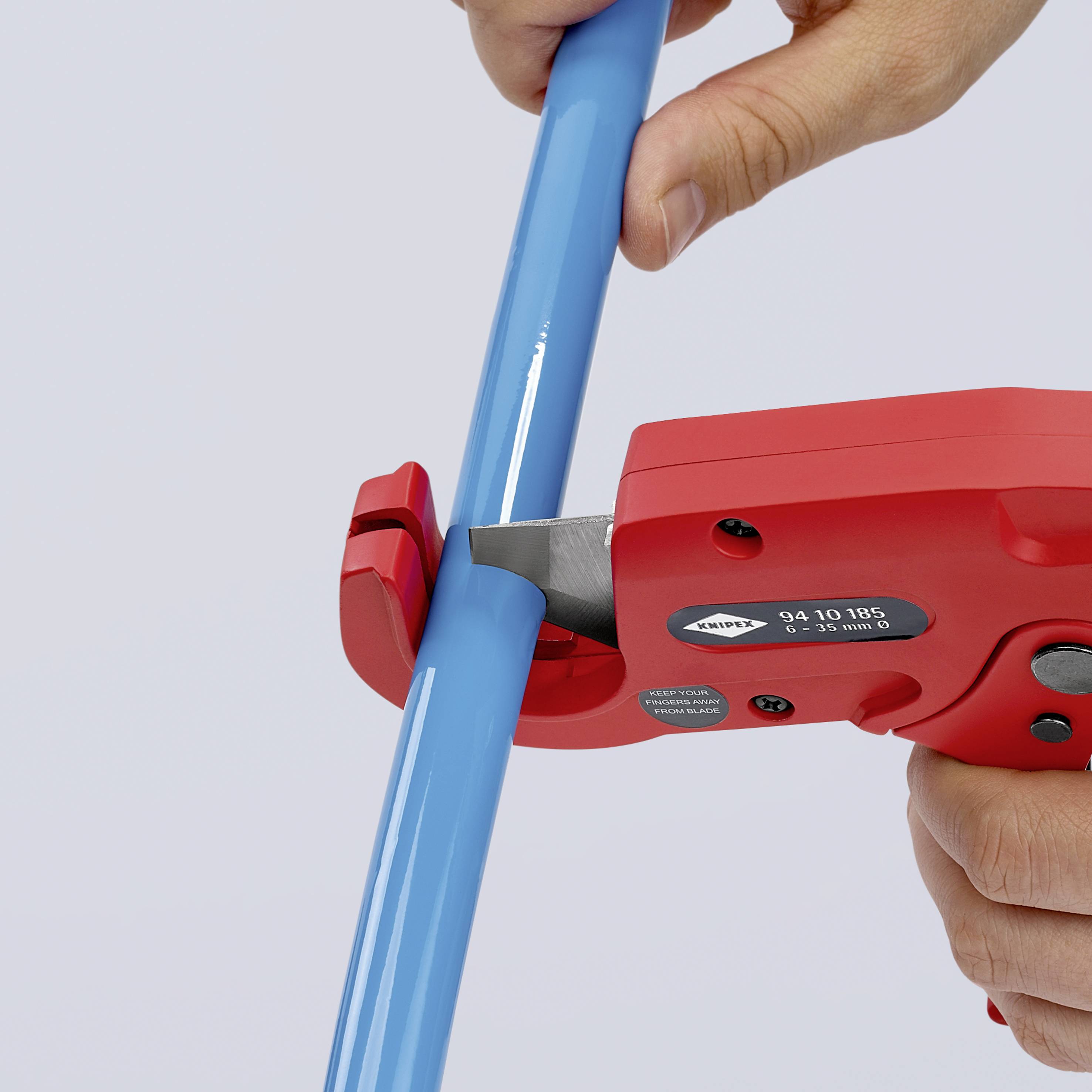 Une main utilise un outil rouge pour mesurer un long tuyau bleu. L'outil affiche une échelle et des valeurs de mesure.
