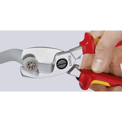 Le coupe-câble 'KNIPEX' coupe un câble épais et rond. Tenu d'une seule main. L'outil est argenté avec des poignées rouges.