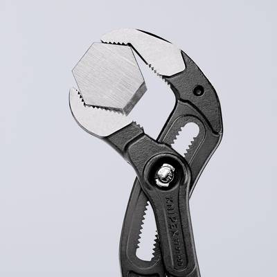 Pince à tuyau maintenant un objet hexagonal, sur un fond gris. Illustre la fonctionnalité et la précision de l'outil.
