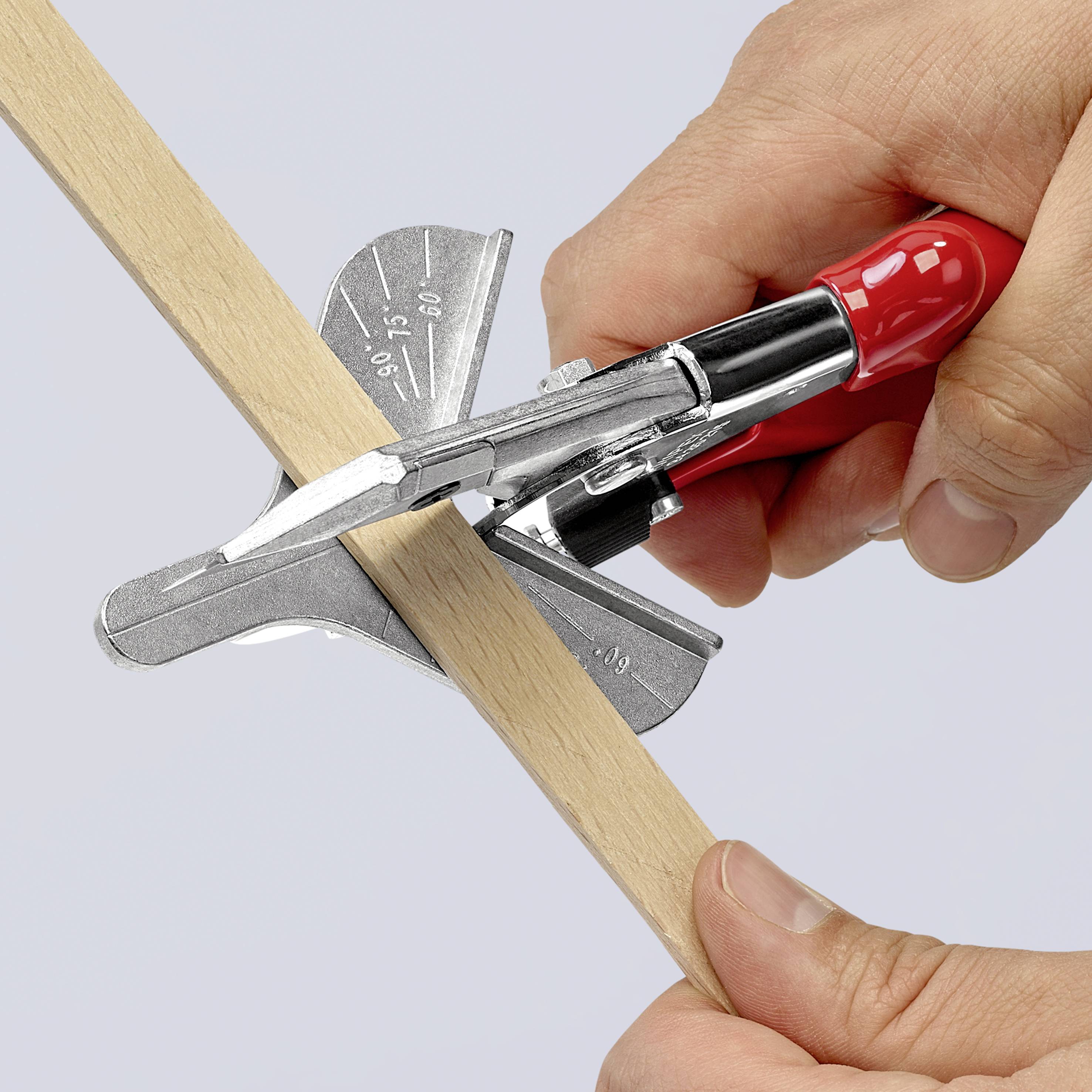 Une personne coupe un morceau de bois avec une scie à onglets rouge sous un angle précis.