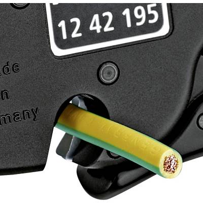 Gros plan d'une pince à dénuder traitant un câble jaune et vert pour le câblage électrique. Certaines parties du câble sont mises à nu.