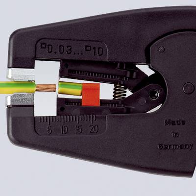 Pince à dénuder coupe un câble. Un outil noir retire l'isolation d'un câble multibrins, avec échelle de mesure visible.