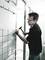 Une personne portant des lunettes de sécurité pose des carreaux sur un mur, en mettant l'accent sur sa précision et ses compétences en construction.