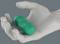 Une main grise tient un petit rouleau de massage vert composé de trois segments connectés, mettant en valeur son design compact et ergonomique.