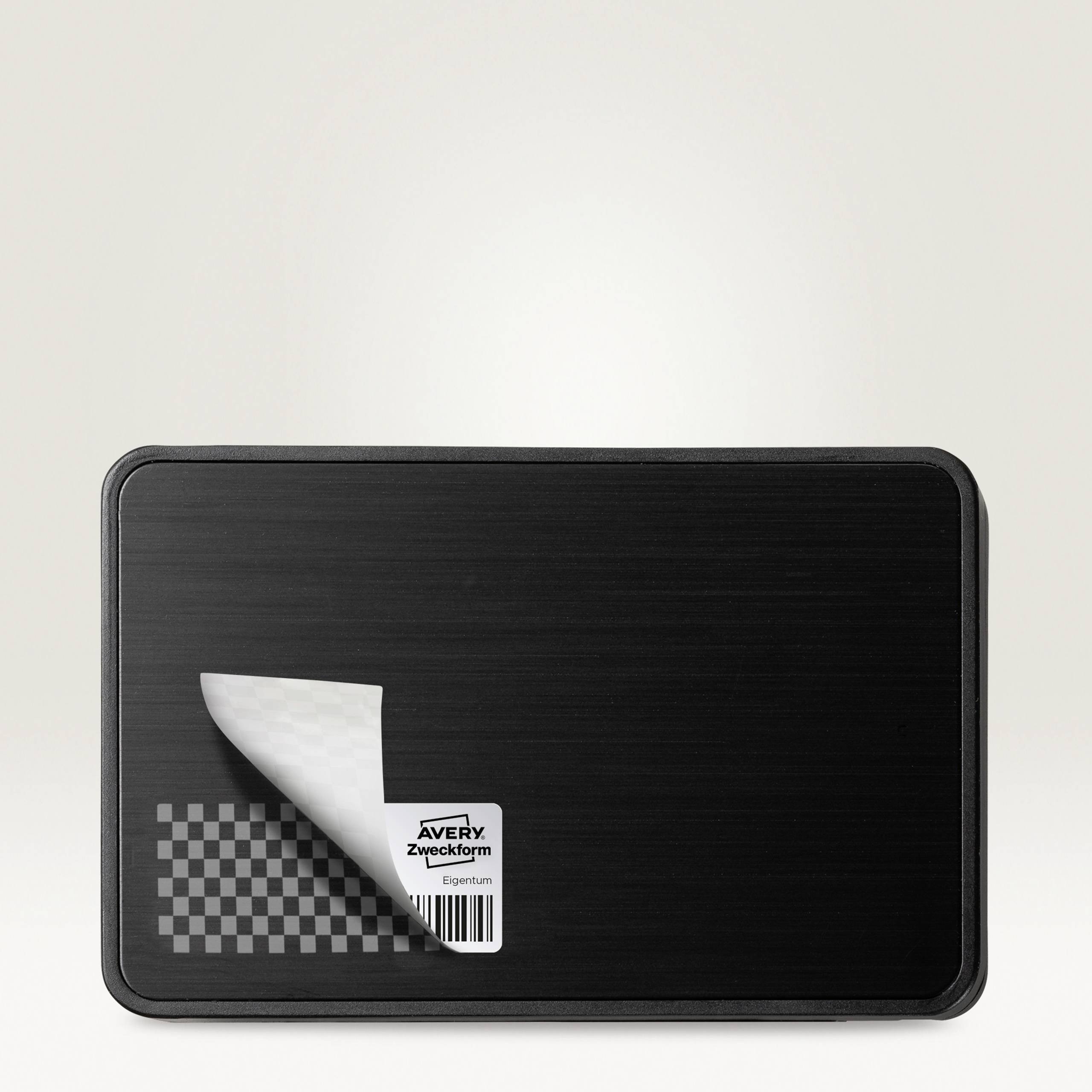 Une étiquette noire rectangulaire avec un effet décollable au coin, affiche la marque : « Avery Zweckform ». Idéale pour l'étiquetage.