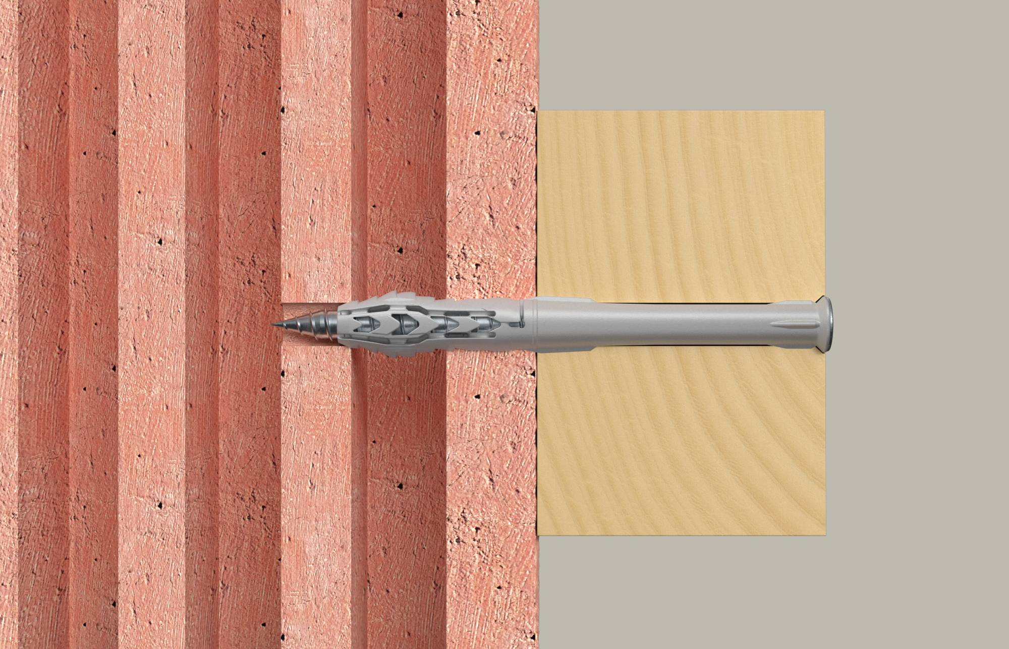 Gros plan d'une vis étant enfoncée dans un mur rosâtre à côté d'une planche de bois clair, montrant l'installation d'une cheville murale ou d'un système de fixation.