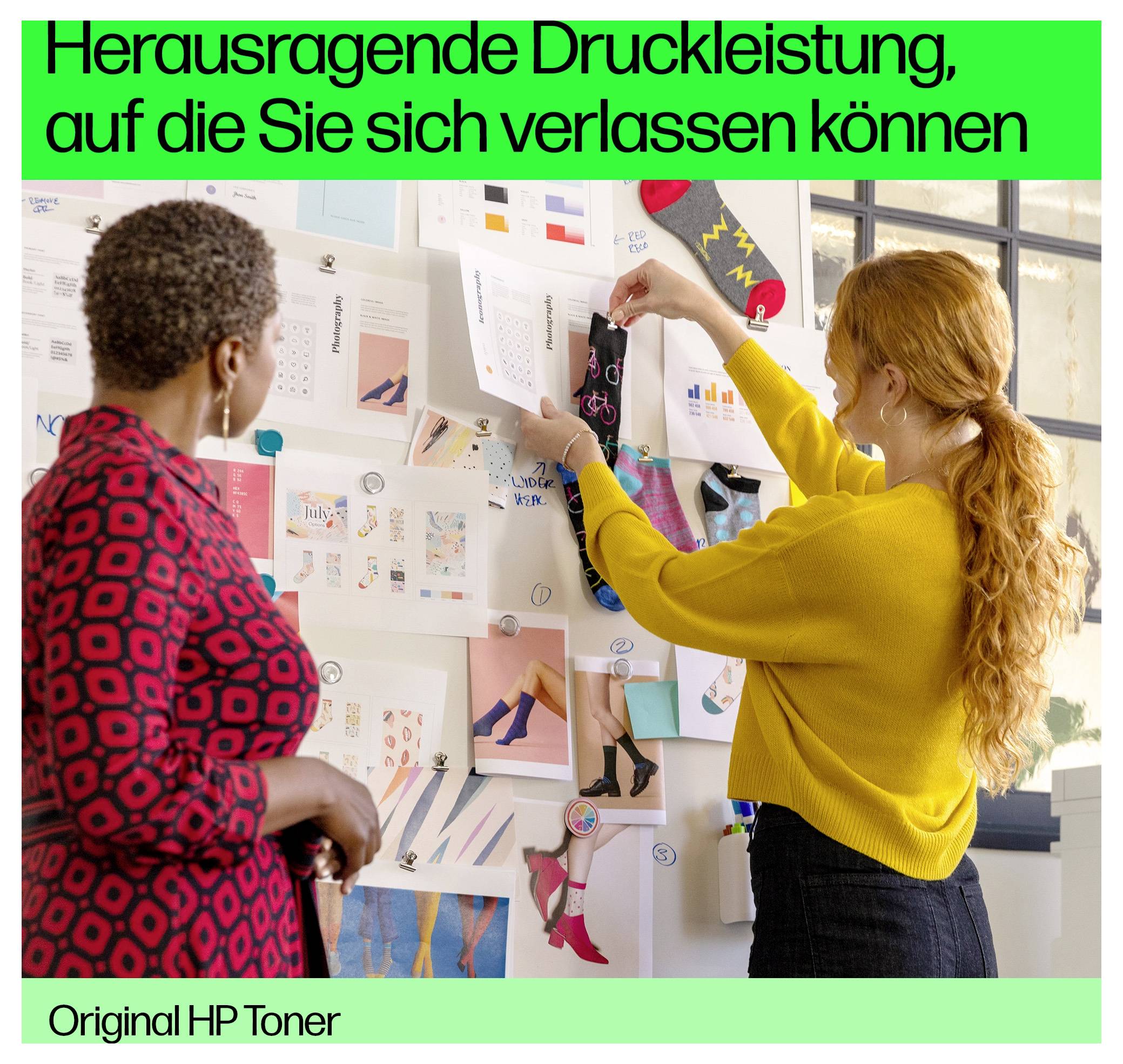 Deux femmes examinent des maquettes de design de mode sur un mur ; le texte publicitaire en allemand se lit « Herausragende Druckleistung, auf die Sie sich verlassen können » et « Original HP Toner ».
