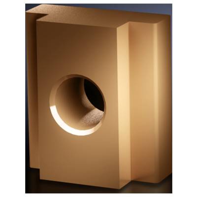Sculpture géométrique brune avec un trou rond au centre, sur un fond sombre.