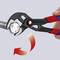 Une main tient une pince Knipex qui fait tourner un écrou. Une flèche rouge indique le sens de rotation.