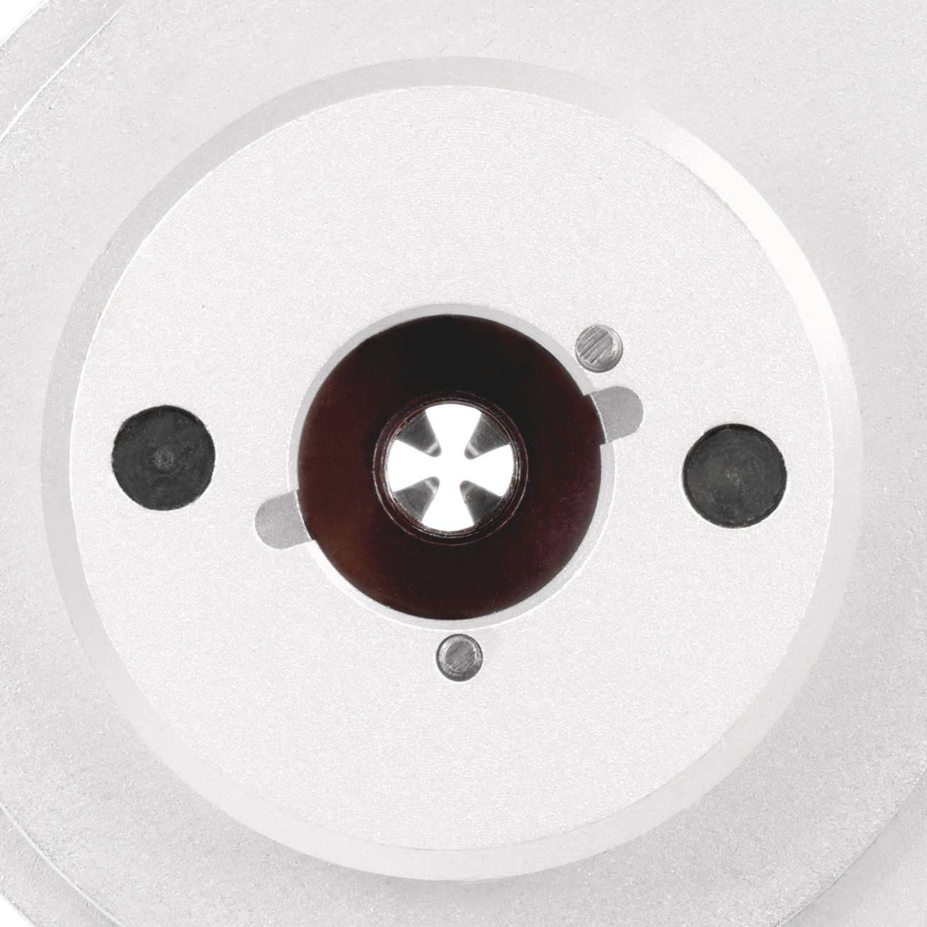 Gros plan d'un objet métallique rond avec un motif en étoile au centre et de petits détails circulaires.