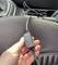 Une personne tient l'interrupteur d'un coussin chauffant 12V dans une voiture. L'interrupteur affiche les options : HI, OFF, LO.