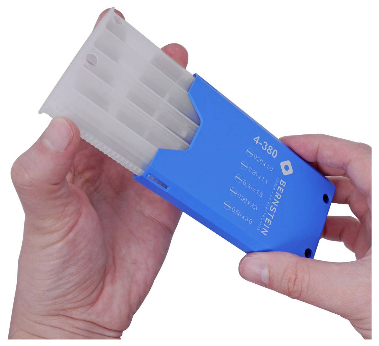 Les mains tenant un boîtier distributeur de graines en plastique bleu portant l'étiquette « BEAMSTEIN » avec des inserts empilés translucides s'étendant du haut.