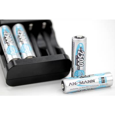 Chargeur avec trois batteries rechargeables insérées et deux batteries supplémentaires devant, le nom de marque 'Ansmann' visible.