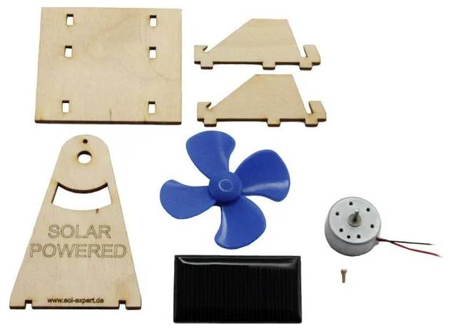 Kit avec des pièces en bois, une hélice, un petit moteur et un panneau solaire. Texte sur le bois : 'Solar Powered'.