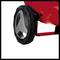 Un appareil rouge avec une grande roue noire est visible en gros plan. La roue possède un insert argenté, probablement une partie d'un outil de jardinage.