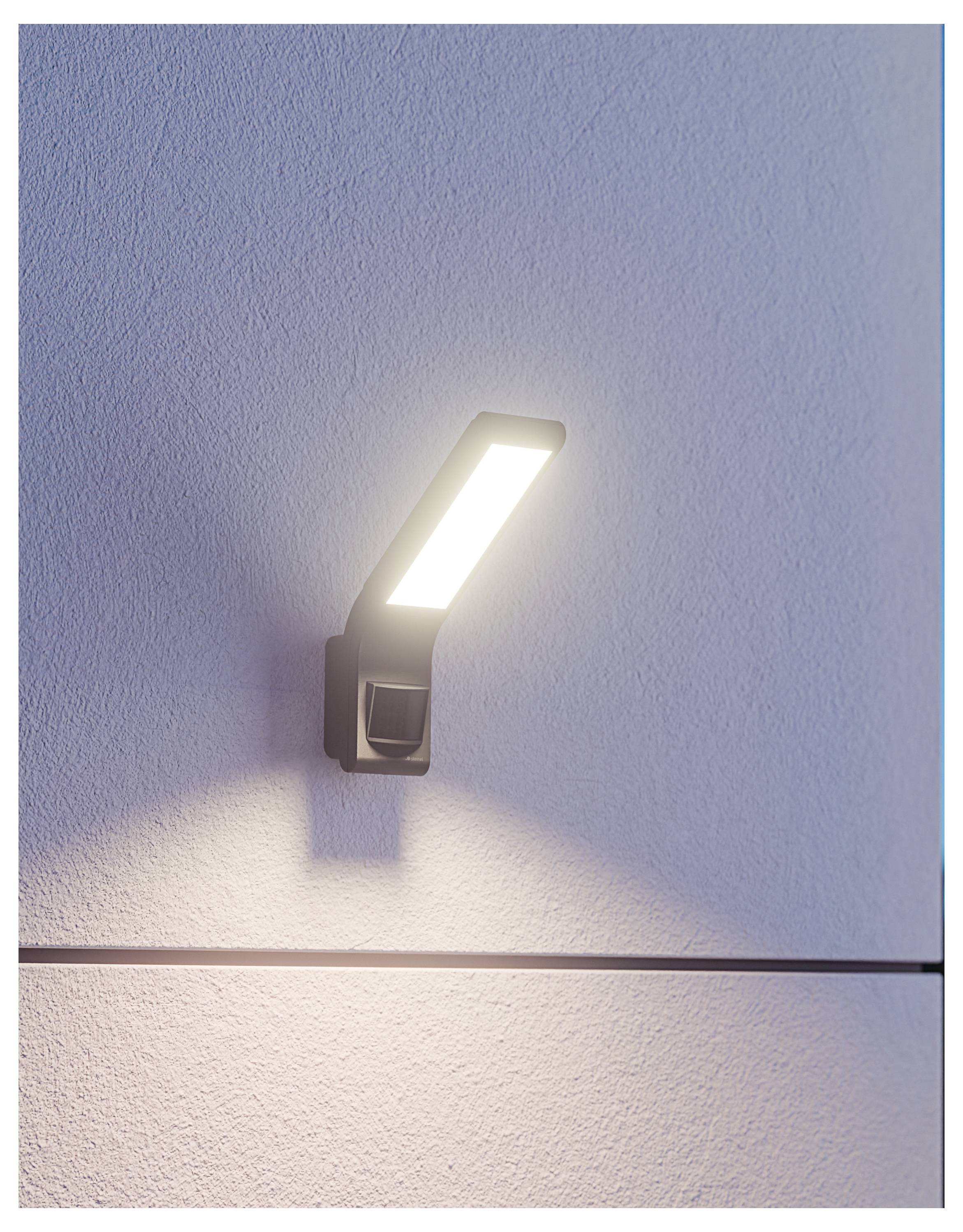 Fixture de luminaire LED murale moderne brillant vers le haut sur un mur texturé, créant un cône de lumière vif et une ombre douce.