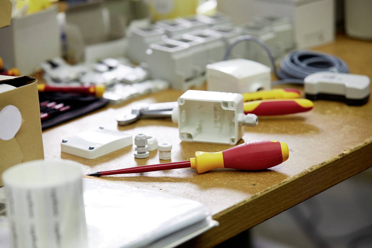 Outils et accessoires électriques sur une table, comprenant des tournevis et des câbles. Préparation pour des travaux d'installation électrique.