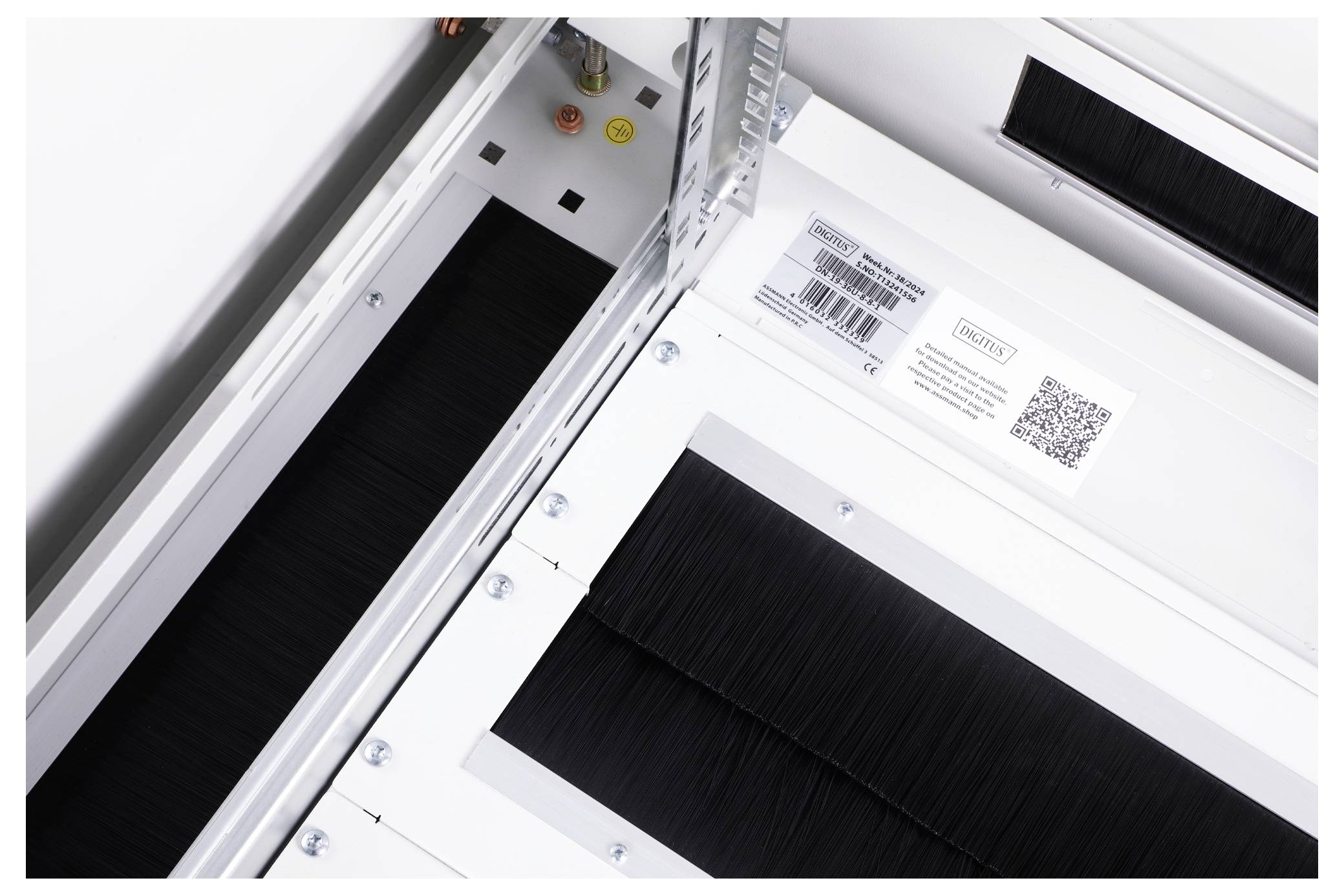Composants de machine métalliques blancs avec insert rectangulaire noir. Code-barres et QR-code en haut pour l'identification. Détails techniques visibles.