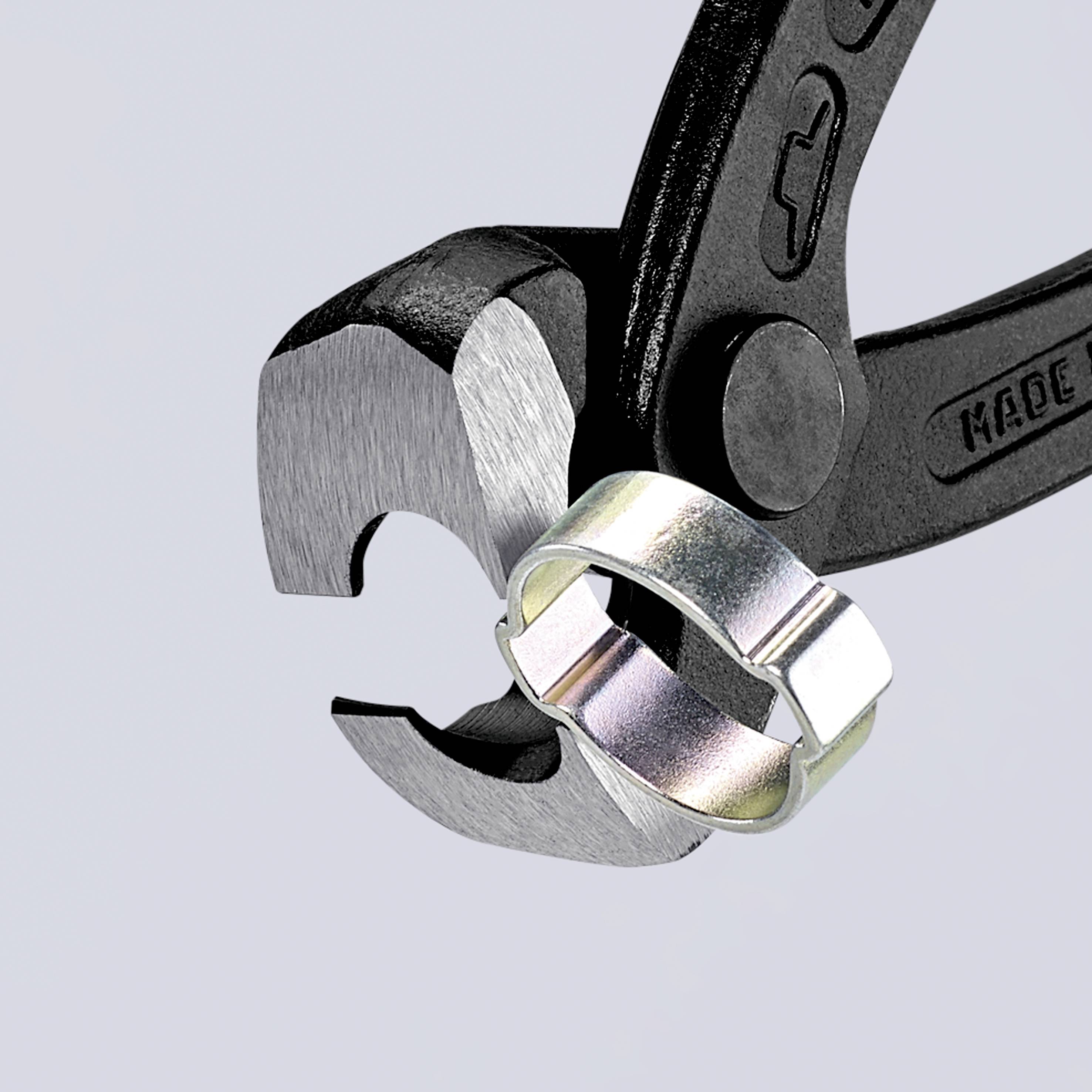 Une clé à molette ajustable maintient fermement un écrou hexagonal en métal. L'arrière-plan est gris.