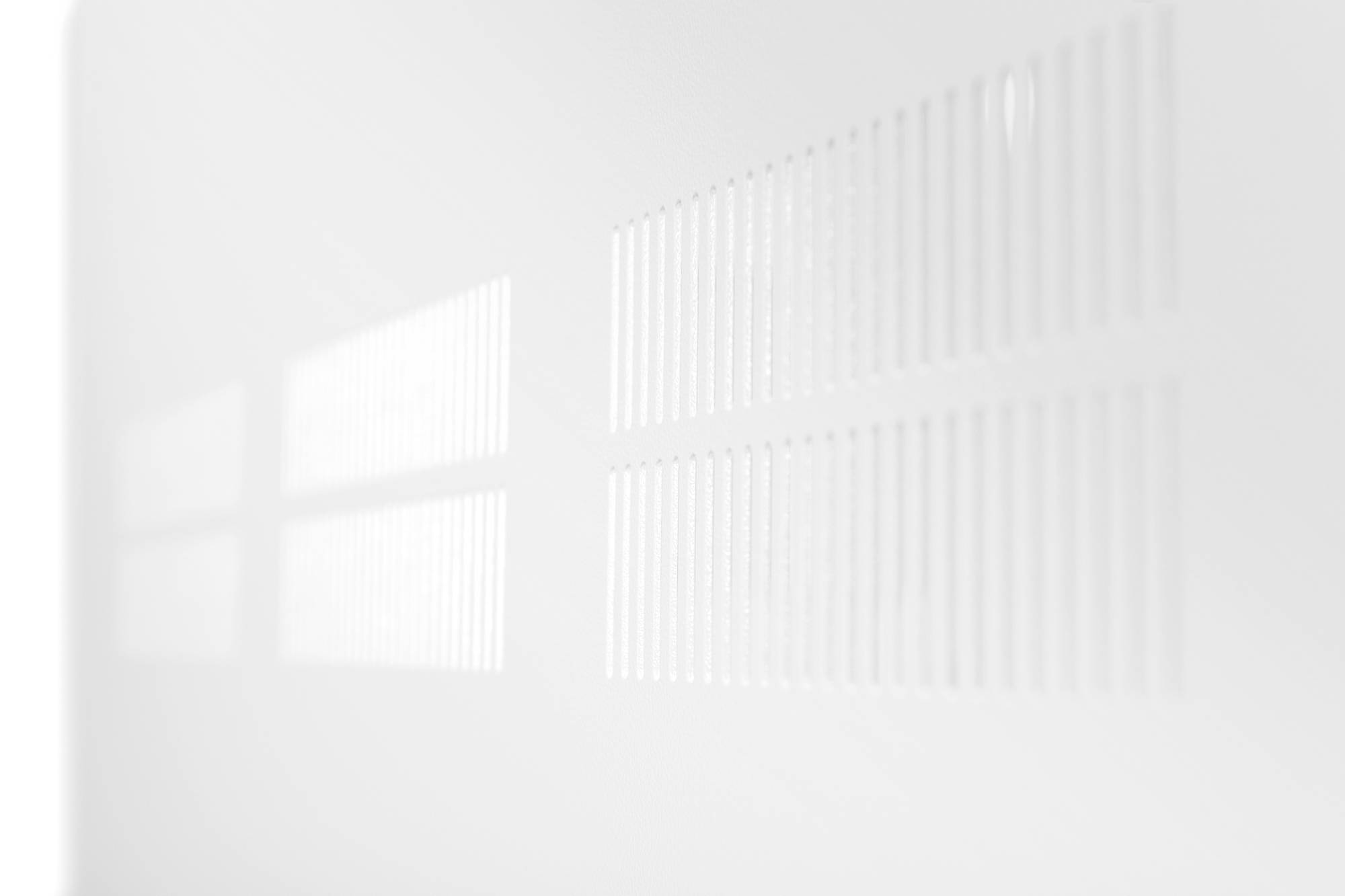 Représentation blanche et abstraite d'une grille floue avec des lignes parallèles projetées par la lumière sur une surface.