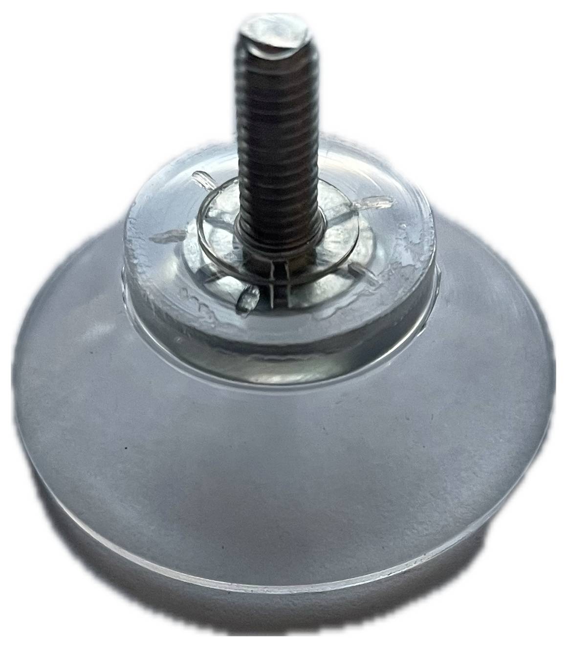 Vis métallique avec un socle en plastique transparent et rond, en gros plan. La vis est insérée au centre du socle.