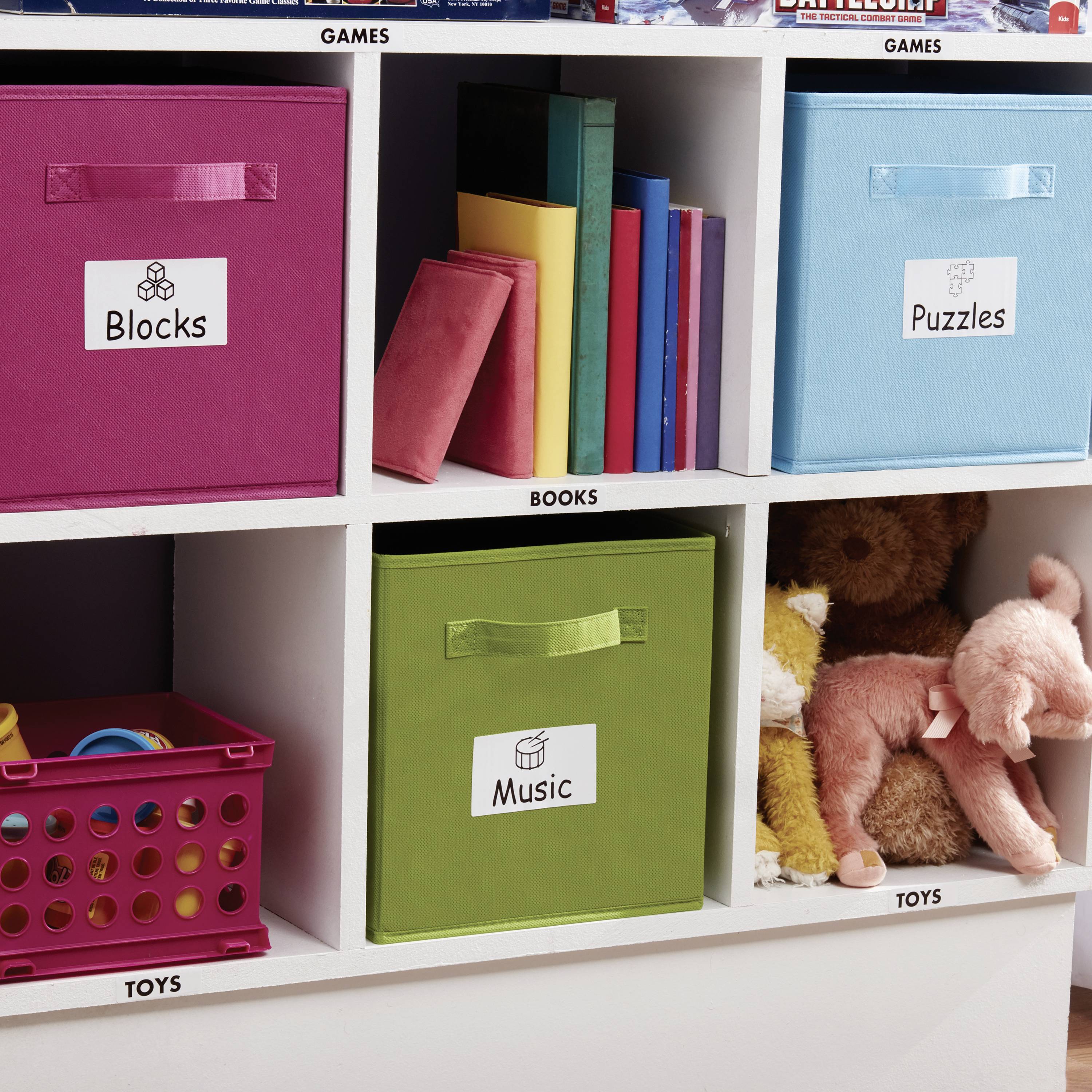 Une étagère avec six compartiments, étiquetés 'Blocs', 'Livres', 'Jeux', 'Musique', 'Puzzles' et 'Jouets'. Chaque compartiment contient des objets correspondants.