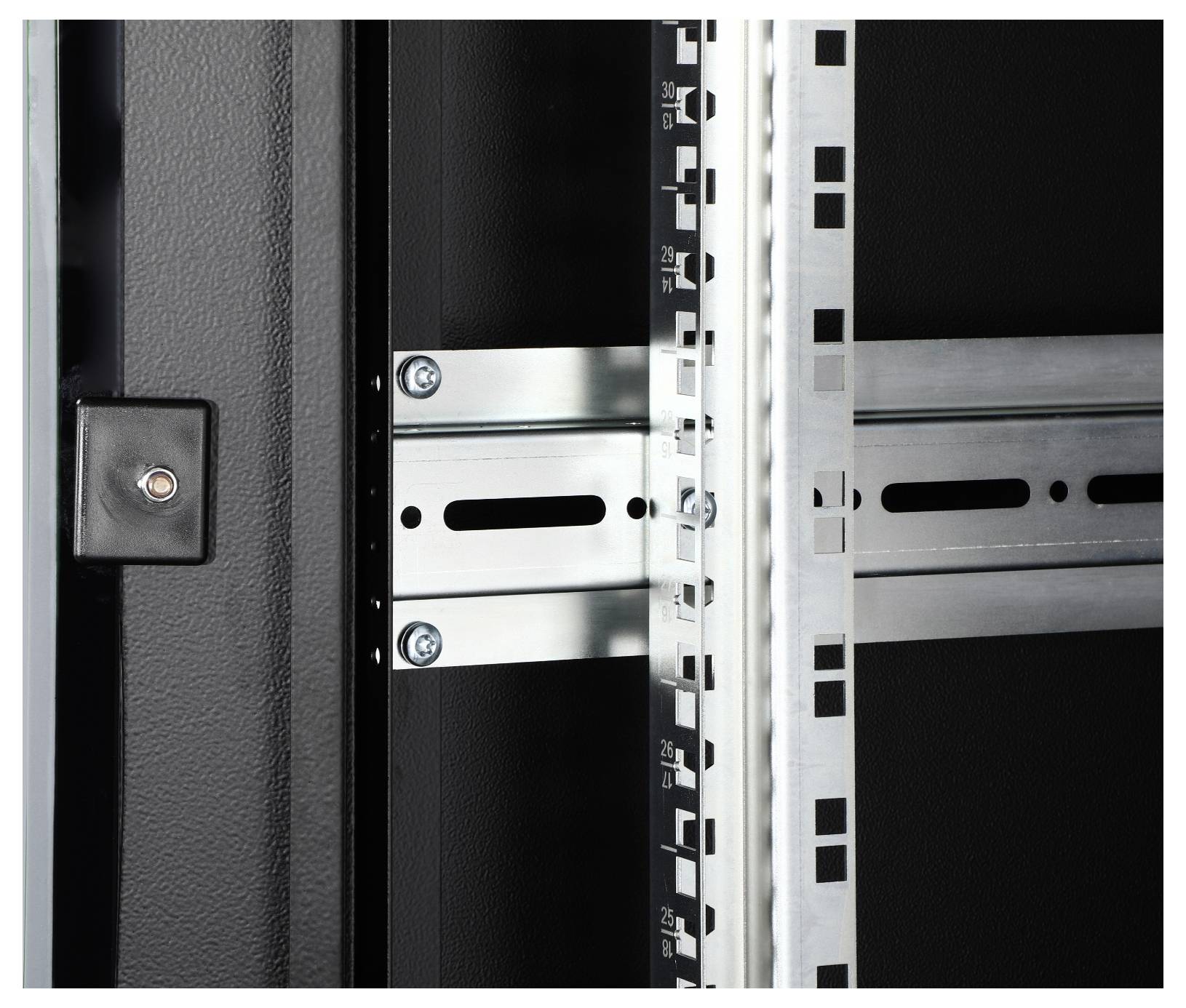 Intérieur d'un rack serveur avec des supports et des rails de fixation. Un bouton ou une lampe noir est visible à gauche.