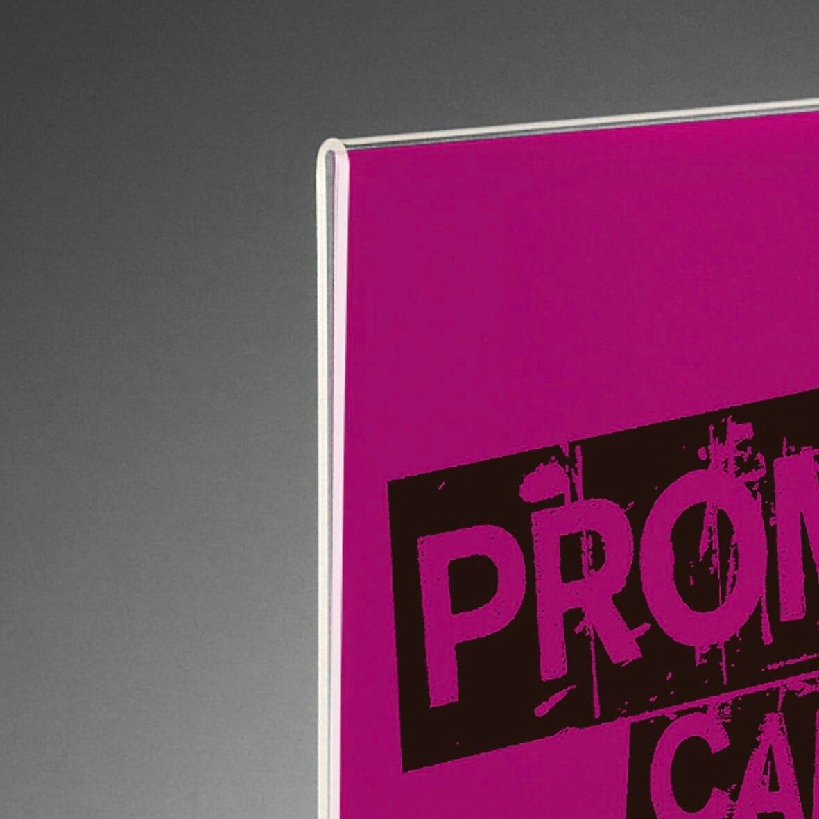 Une affiche rose avec un grand texte noir partiellement visible, probablement liée à un événement ou à une annonce.