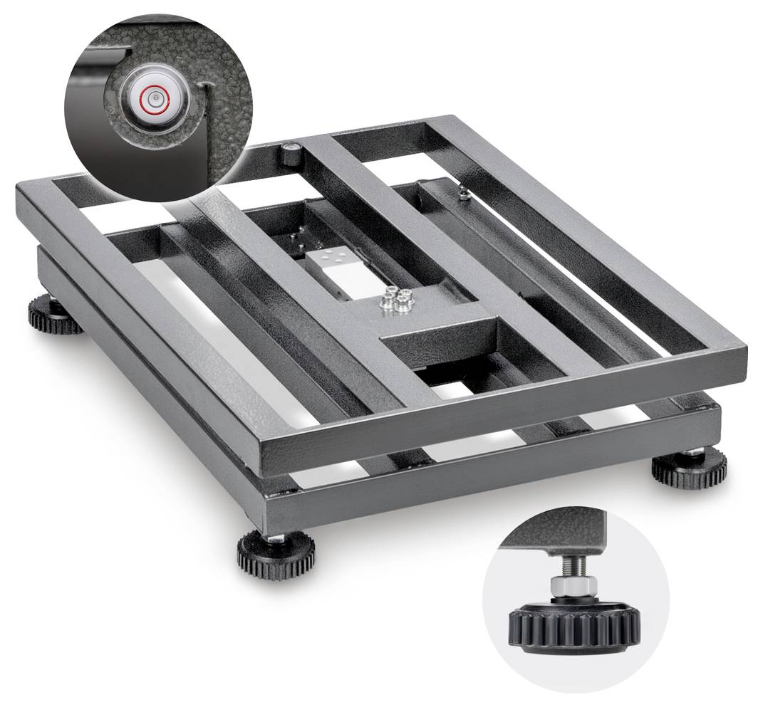 Plateforme rectangulaire noire avec pieds à vis permettant un nivellement précis. Gros plan sur les pieds réglables.